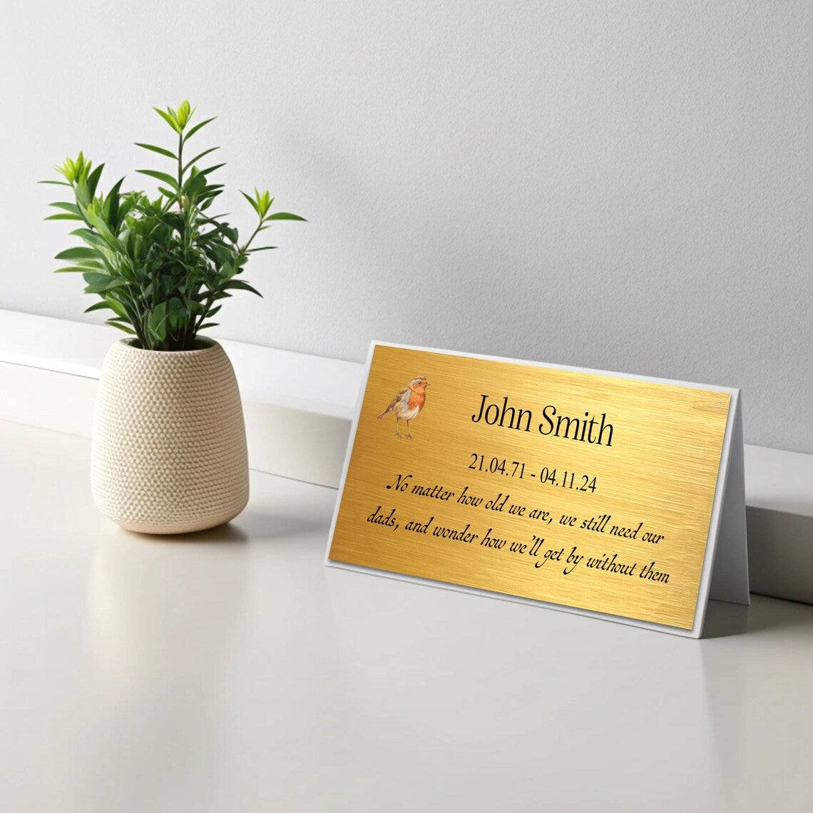 Custom metal memorial plaque with personalized text and robin design, ideal for garden or grave, available in weatherproof gold finish.